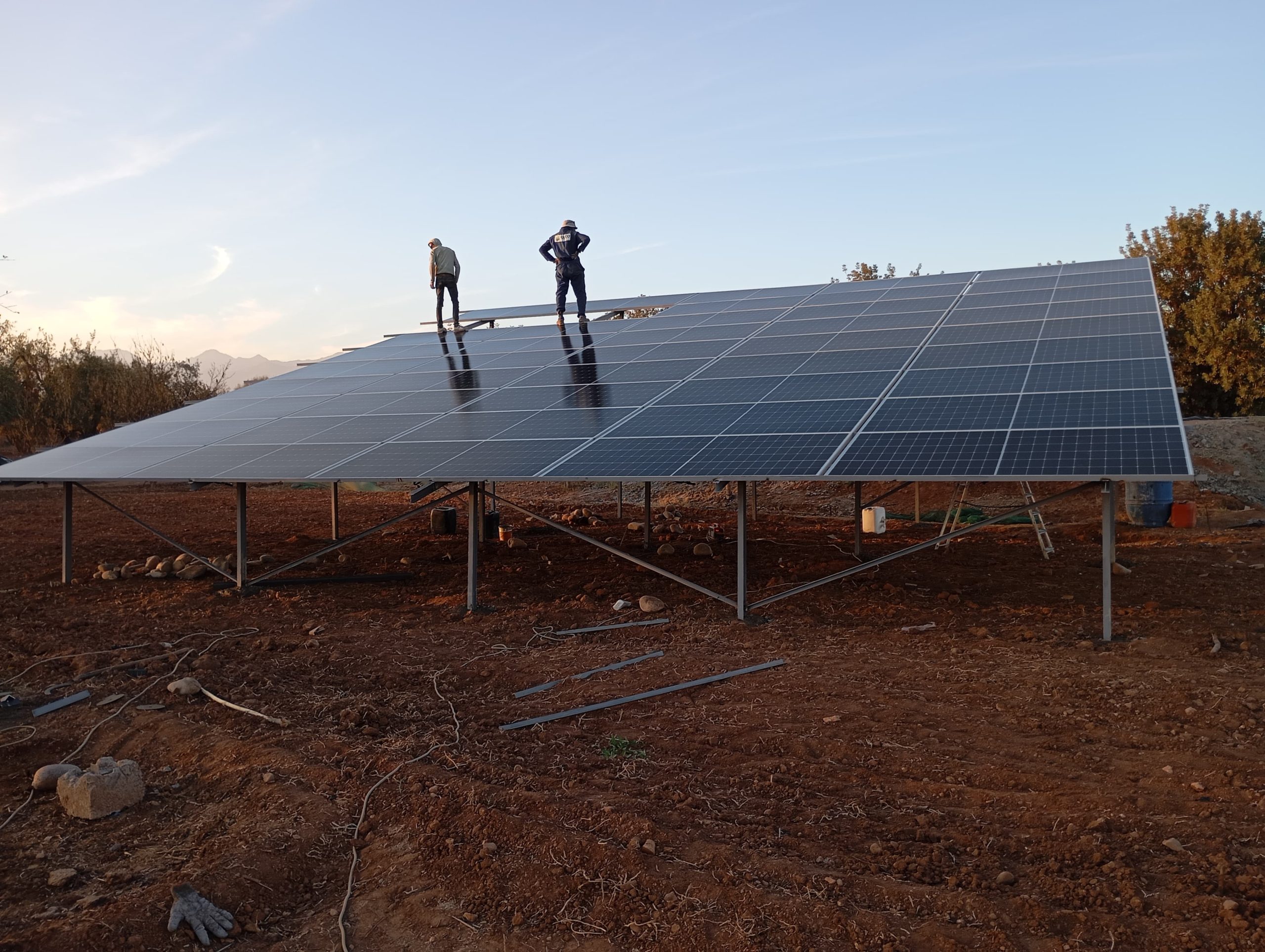 A successful solar project installation in a field with EPC contractors on top of the solar panels