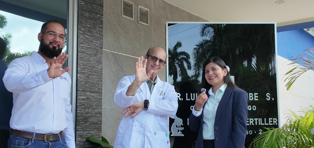 Barranquilla Solar Rooftop Installation by Eco Green Energy with 3 people waving happily in front of an urological center, being interviewed